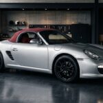 Porsche Boxster série spéciale argent à capote rouge dans un garage éditorial