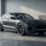 SUV sportif haut de gamme gris foncé garé dans un garage moderne au sol en béton poli, évoquant un Porsche Cayenne Turbo S occasion