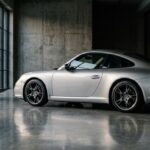 Porsche 911 type 997 argent vue de trois-quarts arrière dans un garage moderne
