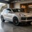 Porsche Cayenne Platinum Edition en finition satin platine dans un garage design, vue trois-quarts avant