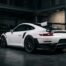 Porsche 991 GT2 RS blanche vue de trois-quarts arrière avec aileron carbone dans un garage industriel