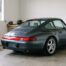 Porsche 911 grise remisée dans un garage sec avec une housse de protection pliée sur un tabouret