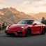 Porsche Cayman rouge sur une route de montagne au coucher du soleil